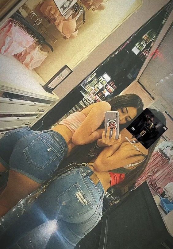 a woman taking a selfie in the mirror with her cell phone and jeans on