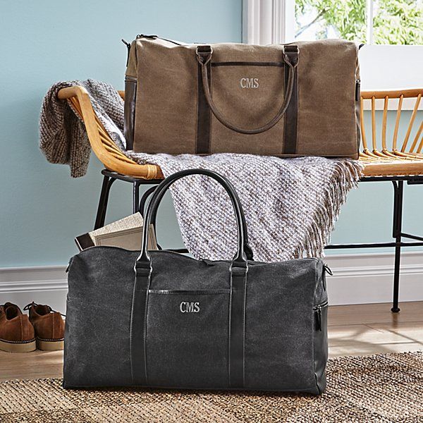 two bags are stacked on top of each other in front of a chair and window