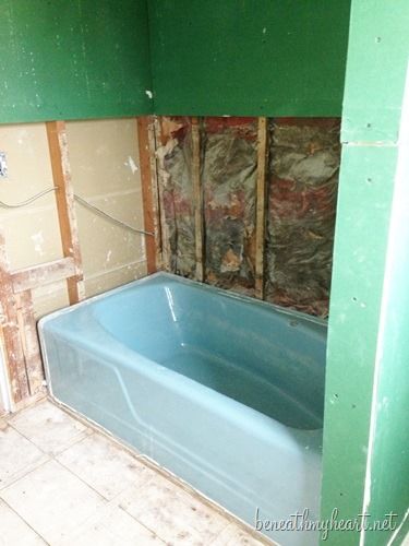 a bath tub sitting inside of a bathroom next to a wall with insulation on it