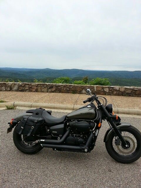 a black motorcycle parked on top of a parking lot