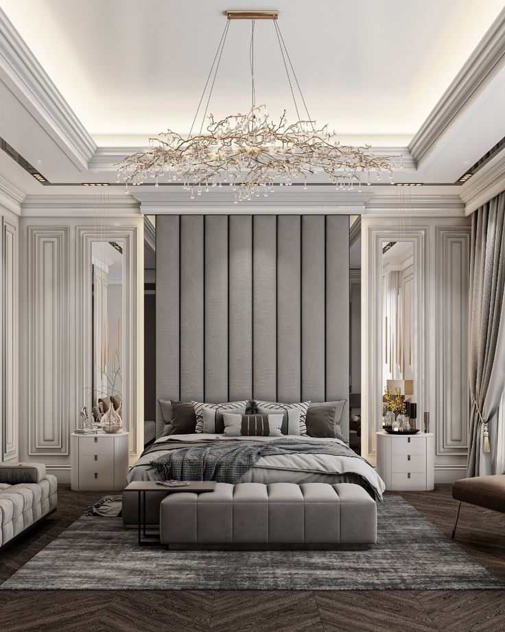 a large bed sitting under a chandelier in a bedroom next to two couches