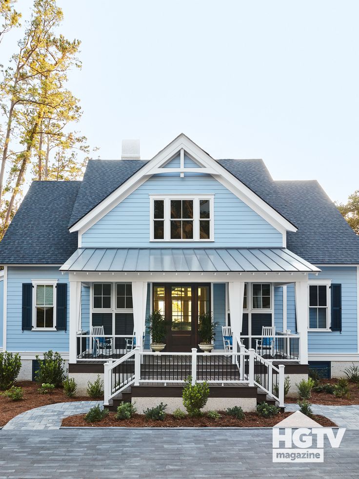 a blue house with white trim on the front porch and steps leading up to it