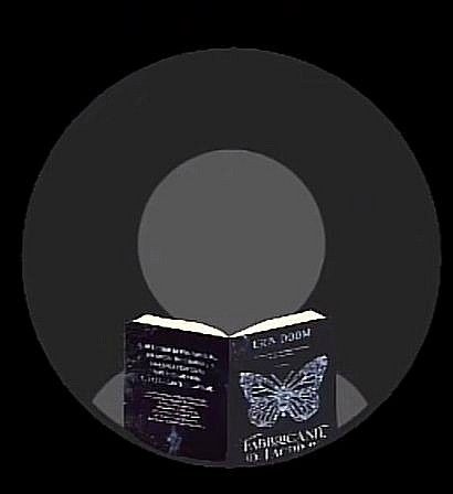 an open book sitting on top of a black circle in the middle of a dark room