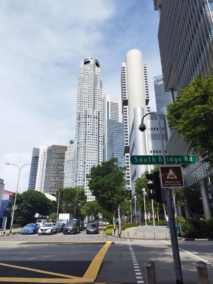 a city street with tall buildings in the background