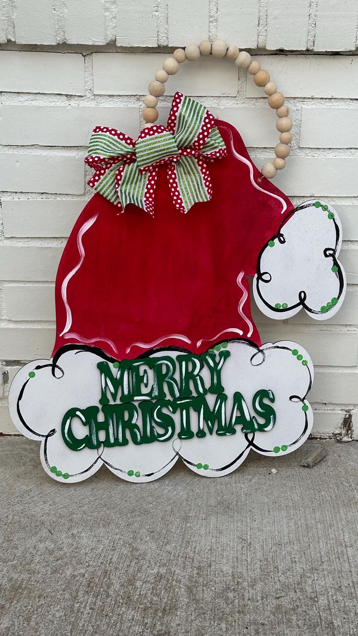 a merry christmas sign hanging on the side of a building