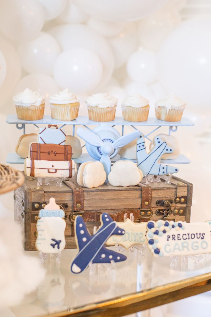 a table topped with lots of cupcakes and cakes