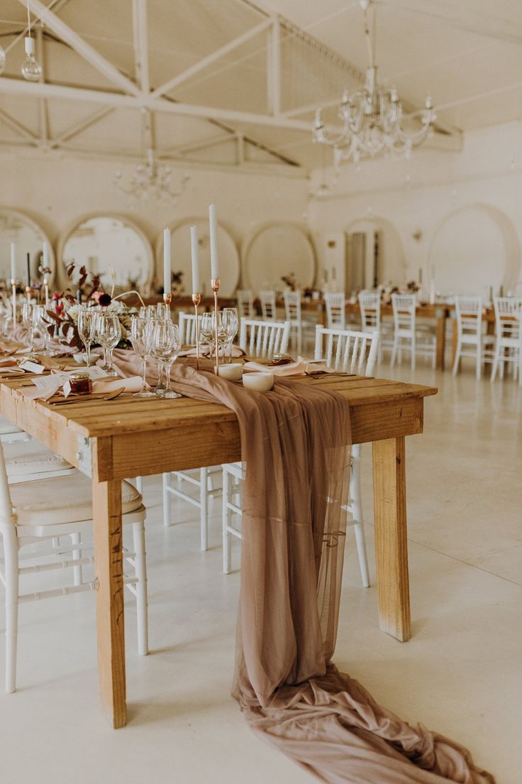 the table is set with wine glasses and place settings for guests to sit down at