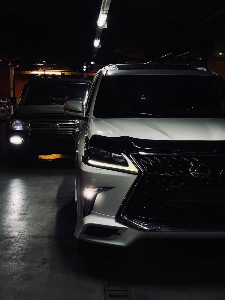 two cars parked in a parking lot at night