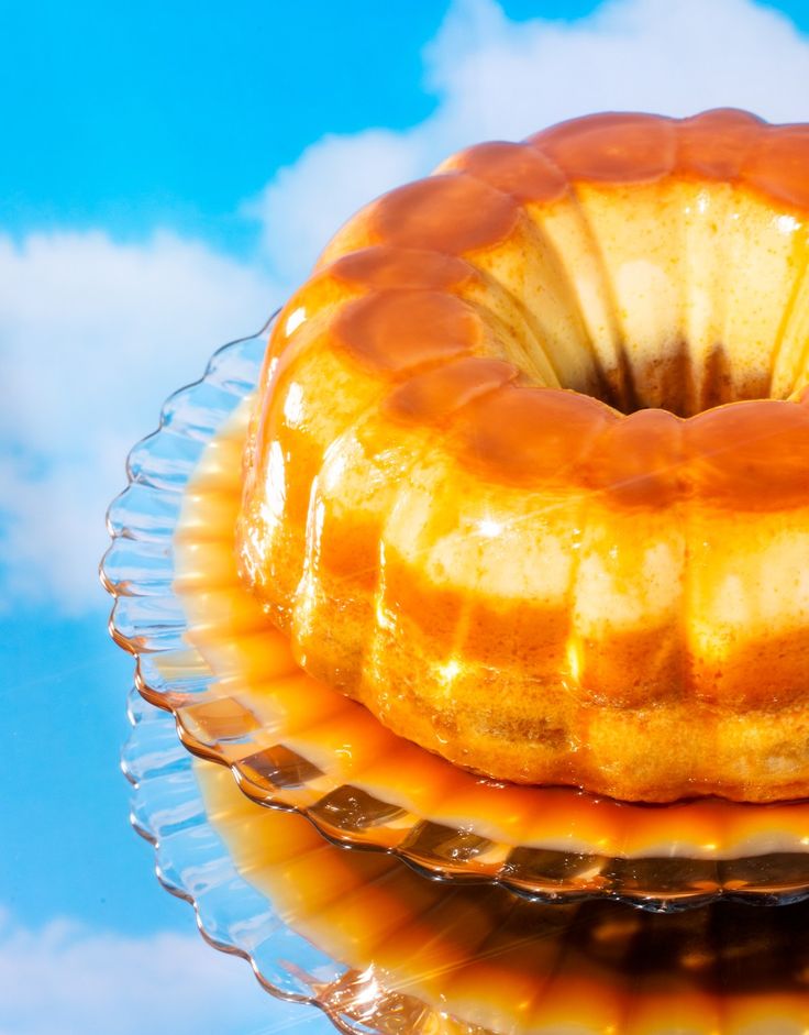 a bundt cake sitting on top of a glass plate with caramel glaze