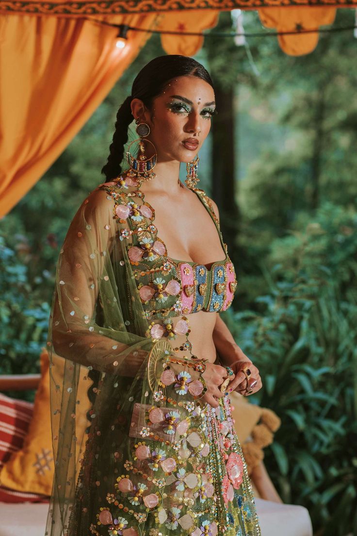 Presenting a custom shaded tulle lehenga in moss green, adorned with 3D flowers, glass cut beads, reflective sequins, and evil eye beads. Paired elegantly with our original tab bralette in moss green, embroidered with glass cut beads, and complemented by an embroidered dupatta. This unique ensemble showcases a perfect harmony of craftsmanship and individuality. Tulle Lehenga, Lehenga Green, Bridal Eye Makeup, Evil Eye Beads, Green Lehenga, Indian Dresses Traditional, Embroidered Lehenga, Traditional Indian Outfits, Custom Shades