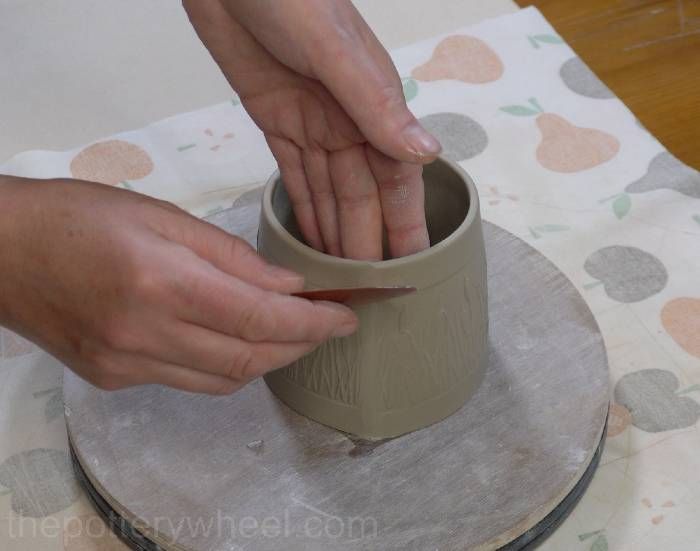 someone is making a vase out of clay on a tablecloth with circles around it