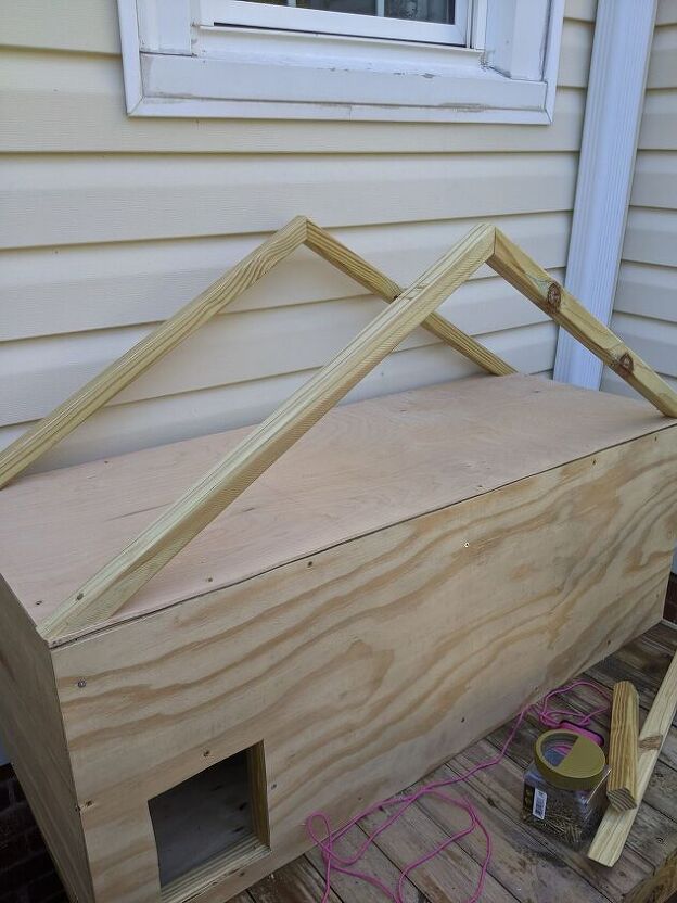 a wooden structure sitting on top of a wood pallet next to a building window