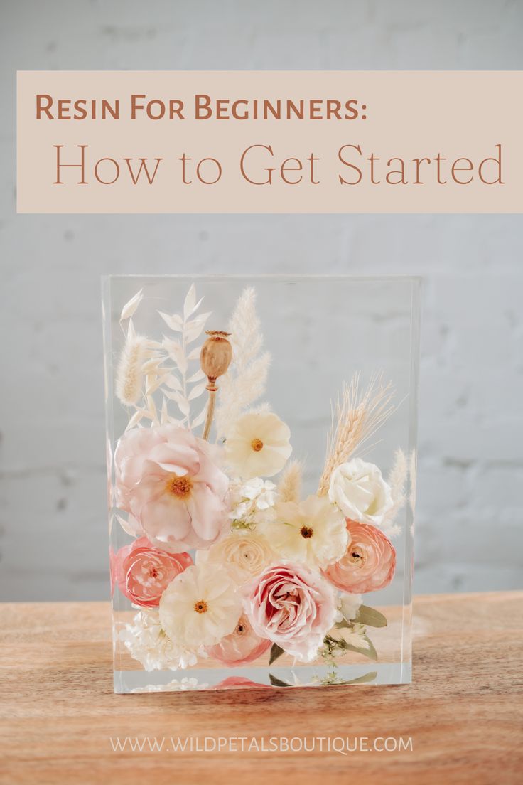 a clear vase filled with flowers on top of a wooden table