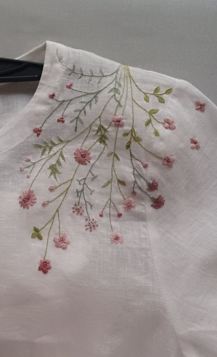 a pair of scissors sitting on top of a piece of white cloth with pink flowers