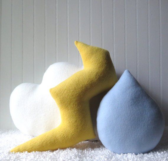 two different colored pillows sitting next to each other on a white carpeted floor in front of a wall