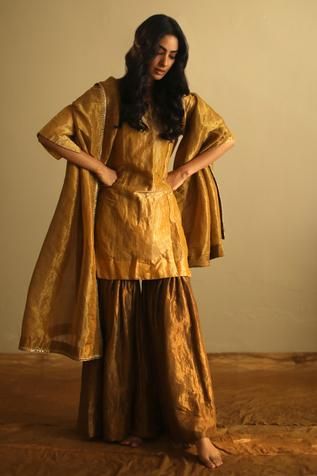 Ochre kurta with zardozi embroidery and round-neck. Paired with sharara.
Components:2
Neckline:Round
Sleeve Length:Three quarter
Fabric:Handloom Tissue 
Color:Yellow
Note: Dupatta worn by the model is not for sale - Aza Fashions Gold Dupatta, Kurta And Sharara Set, Kurta And Sharara, Kurta Sharara, Zardozi Embroidery, Dhoti Pants, Sharara Suit, Embroidered Border, Dream Wedding Ideas Dresses