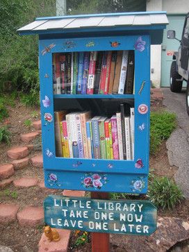 a blue book shelf with books on it and a sign that says little library take one now leave one later