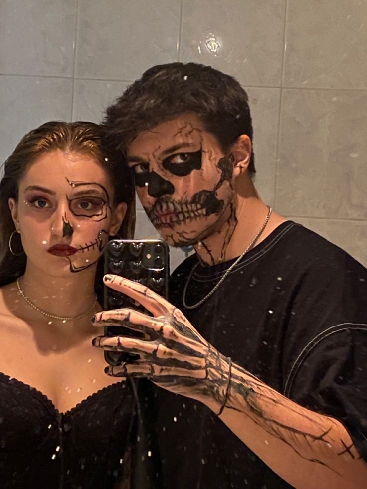 a man and woman in skeleton makeup taking a selfie