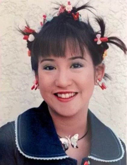 an old photo of a woman with hair in buns and flowers on her head