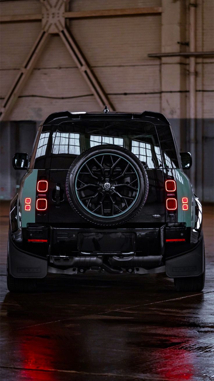 the back end of a black car parked in a garage