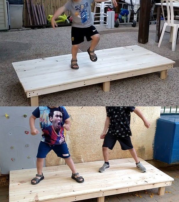 two boys are jumping on some wooden boards