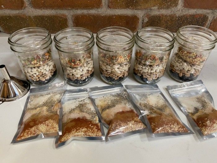 six jars filled with food sitting on top of a counter