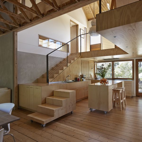 a kitchen and living room with stairs leading up to the second floor