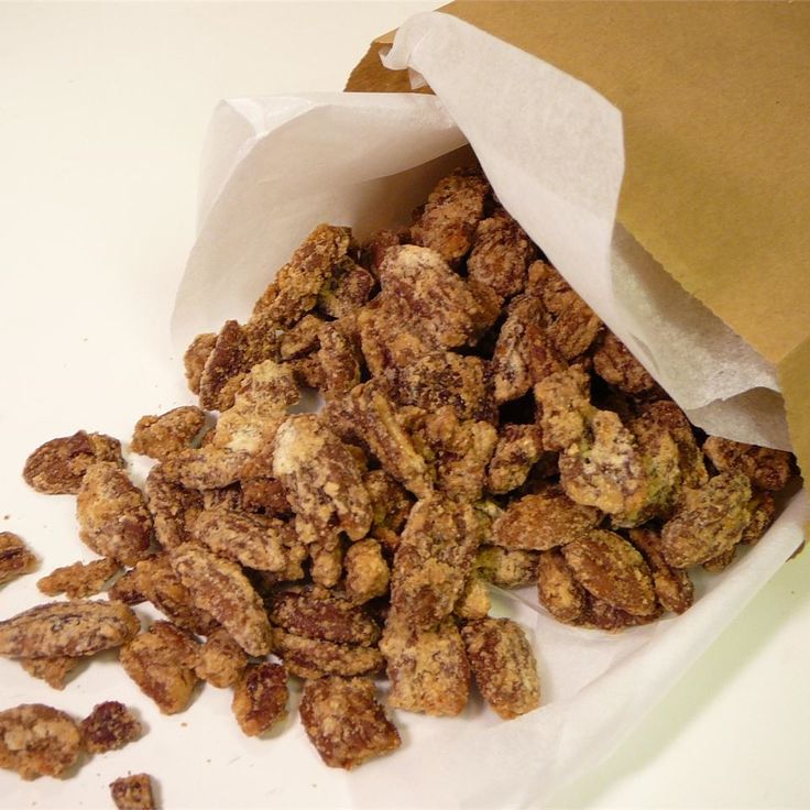 a bag full of nuts sitting on top of a white table next to a brown paper bag