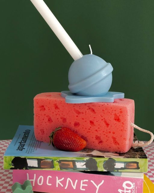 a piece of cake sitting on top of two books with a candle sticking out of it