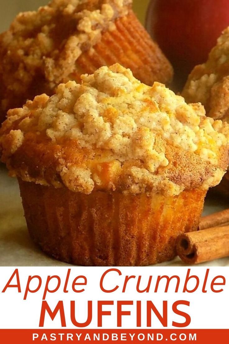 apple crumble muffins with cinnamon sticks and an apple in the background text reads, apple crumble muffins