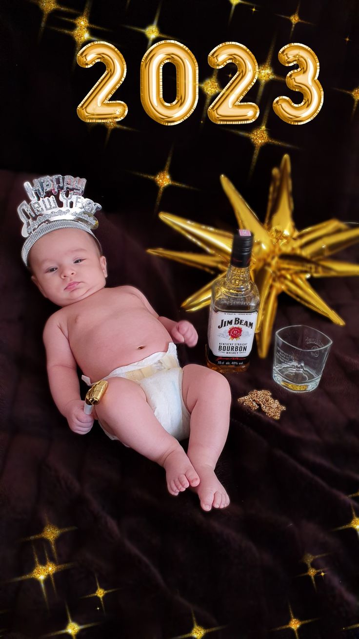 a baby wearing a diaper and a tiara next to a bottle of whiskey