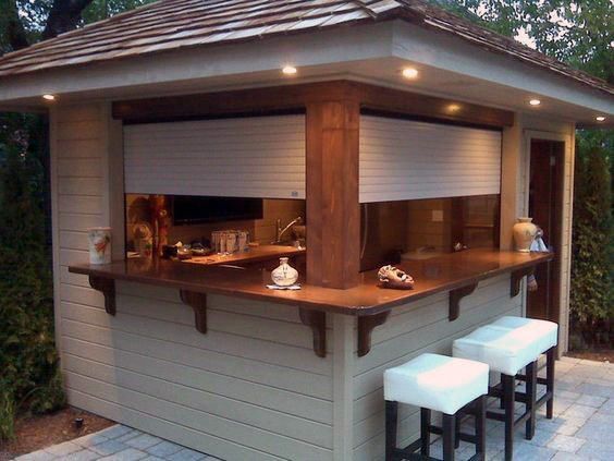 an outdoor bar with three stools next to it