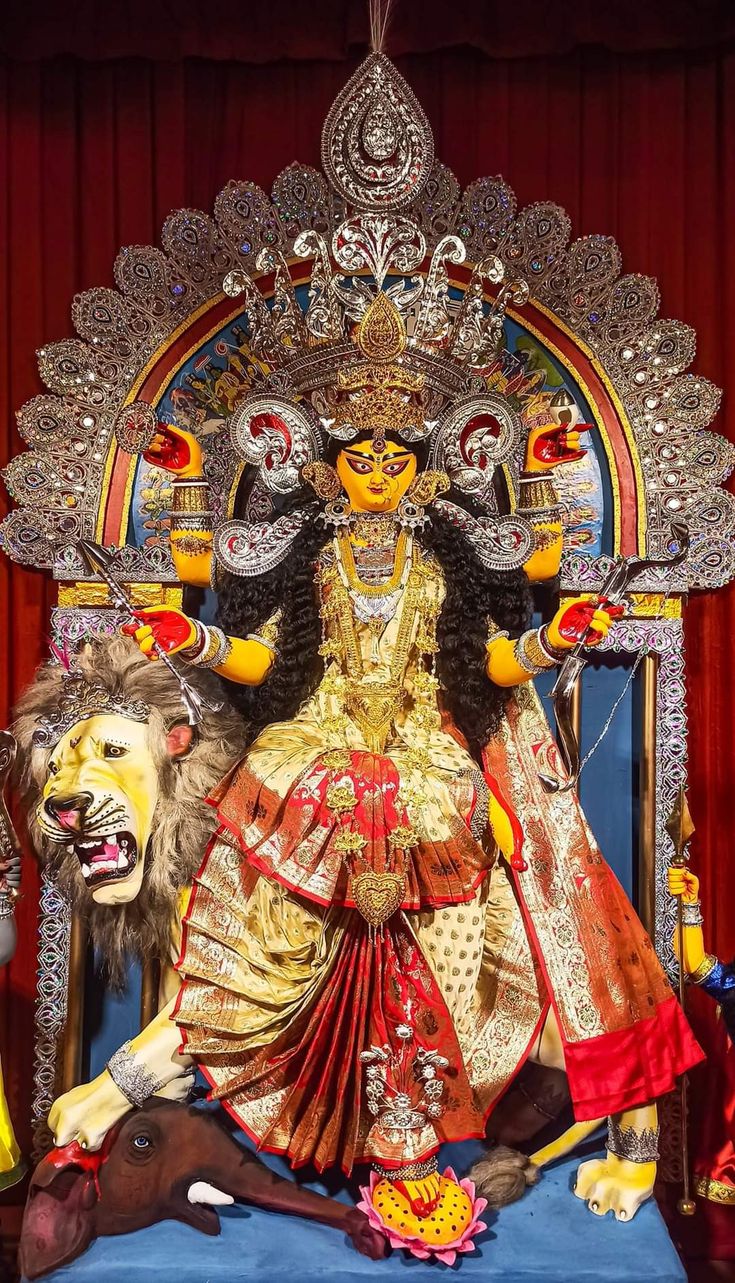 a statue of a woman sitting on top of a chair next to a lion mask