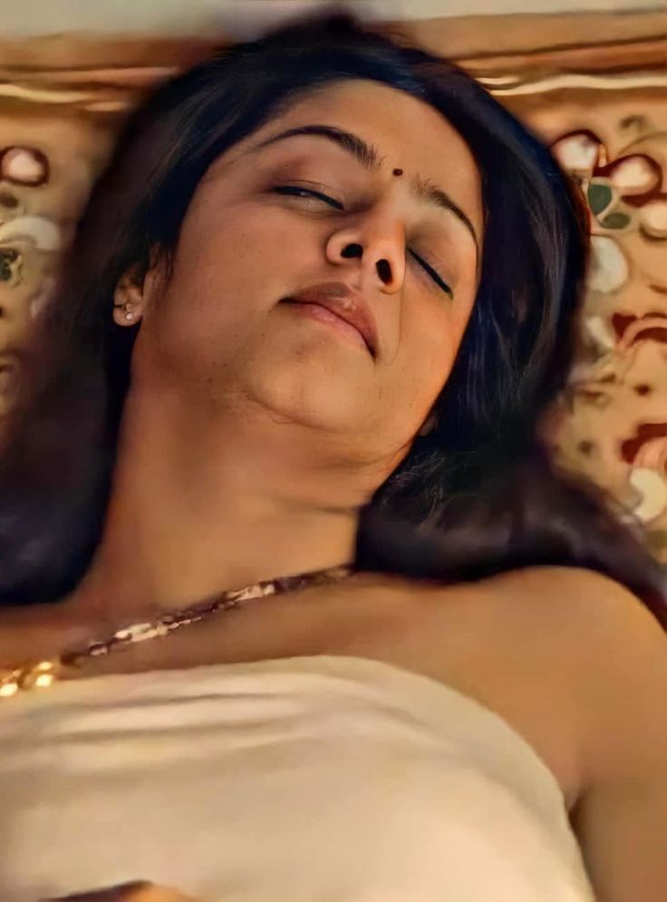 a woman laying in bed with her eyes closed