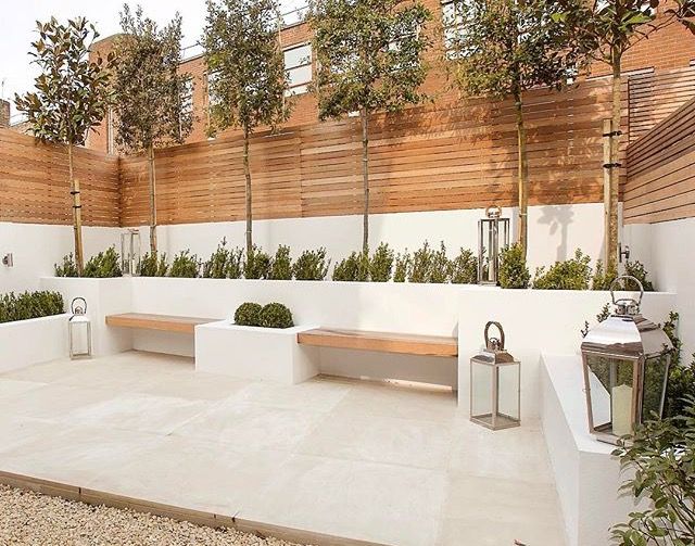 an outdoor seating area with benches and potted trees