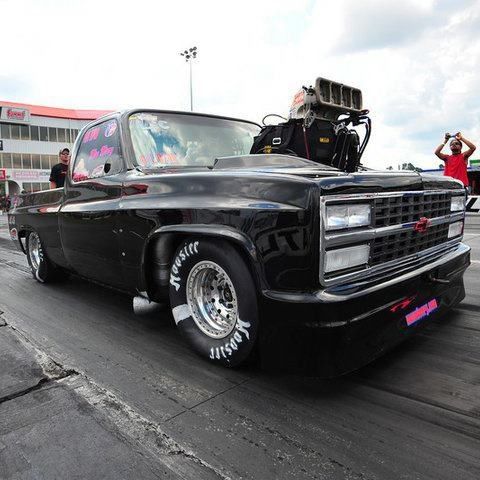 a black truck parked on top of a race track