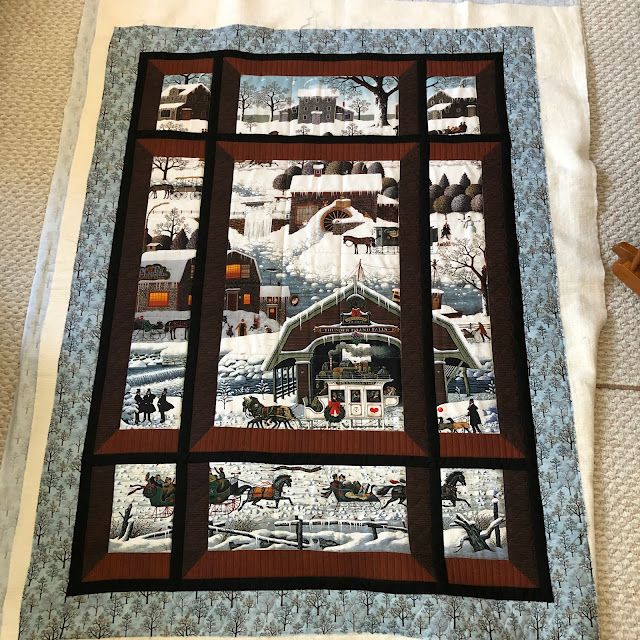 a quilted wall hanging on the side of a bed with people walking in it