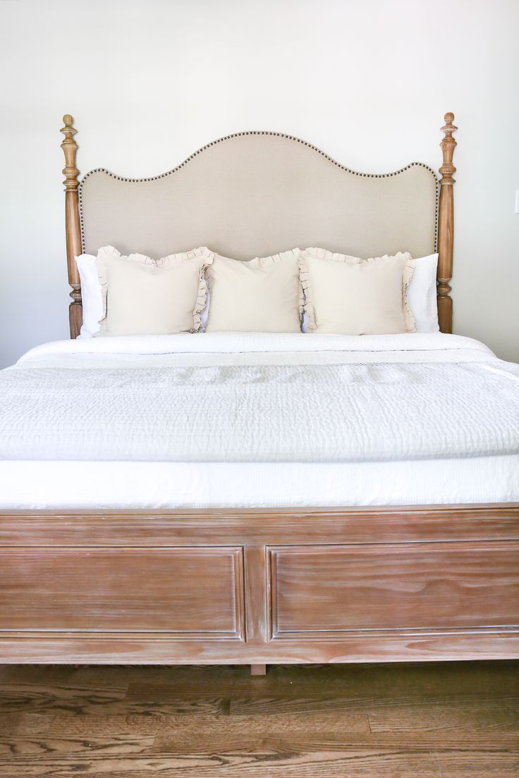 a large bed with white sheets and pillows