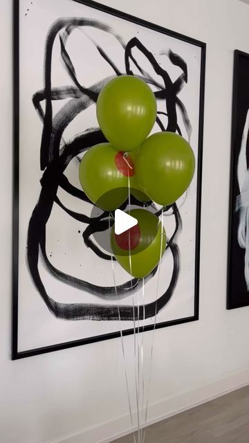 green balloons floating in the air next to two black and white pictures on a wall