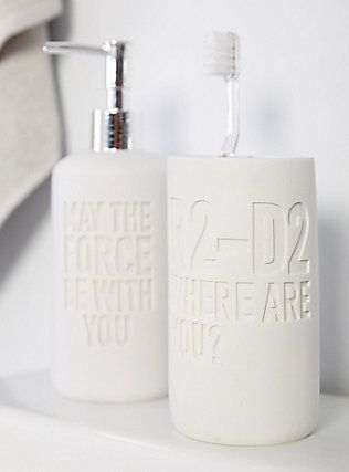 two white ceramic toothbrush holders on a shelf