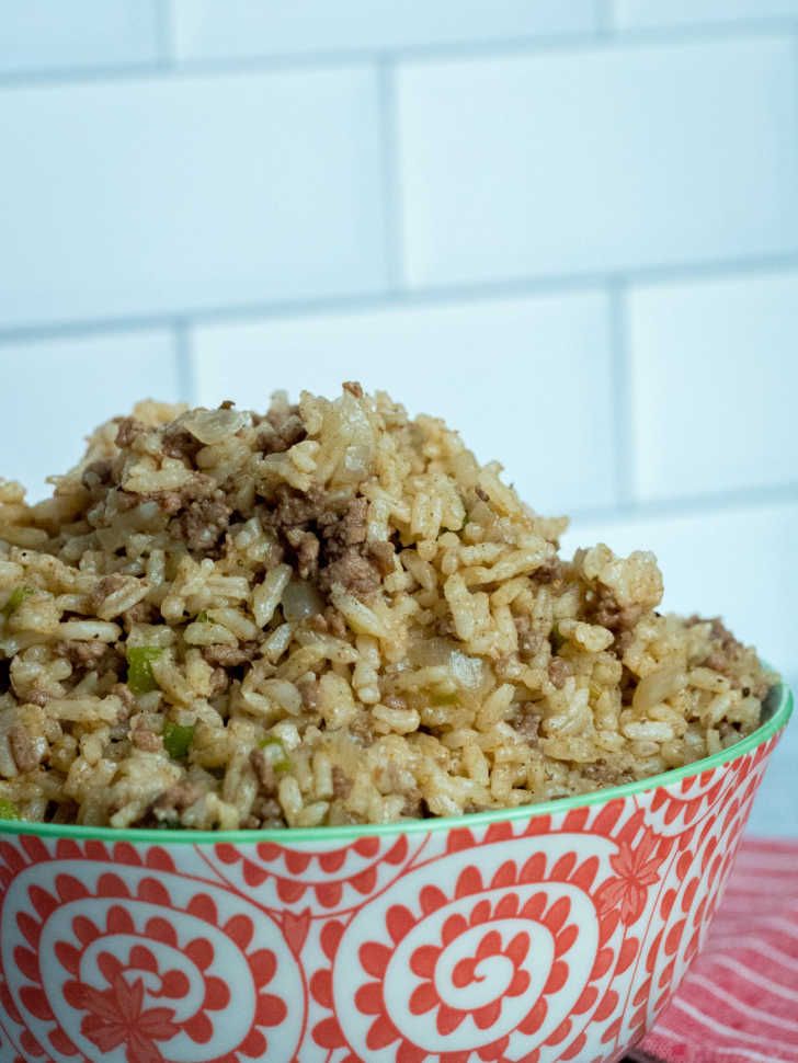 a bowl filled with rice and meat on top of a table