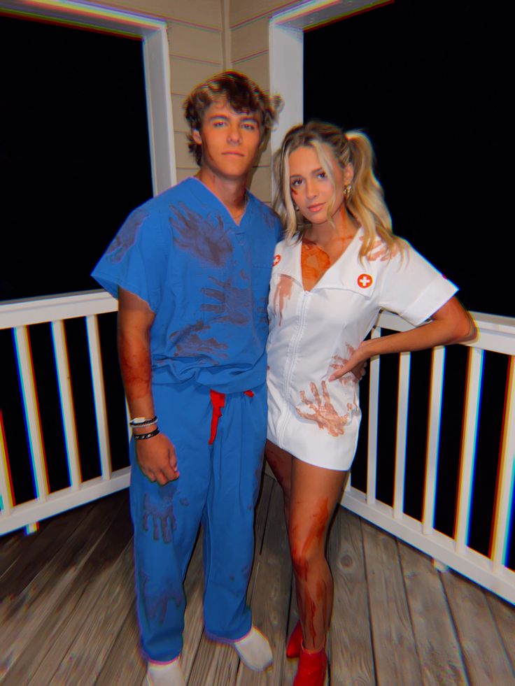 a man and woman dressed in costumes posing for a photo on a porch at night