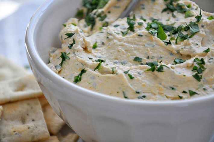 a white bowl filled with dip next to crackers