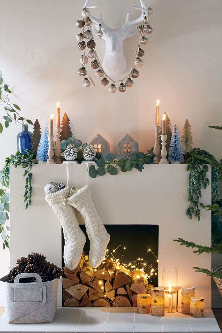 a fireplace decorated for christmas with candles and stockings hanging from it's mantel