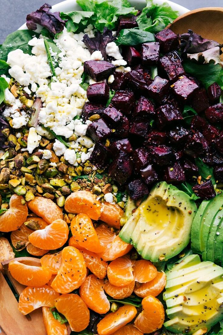 a salad with carrots, avocado, beets and feta cheese