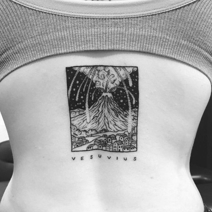 the back of a woman's stomach with an image of a volcano on it