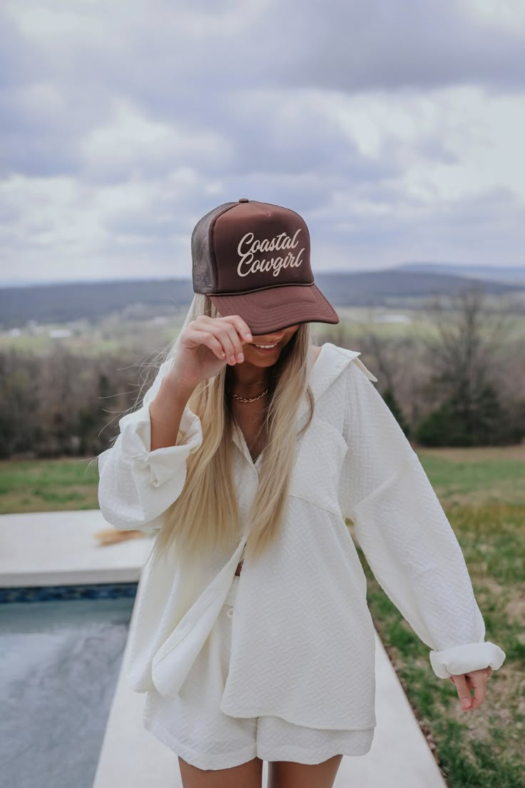 Coastal Cowgirl Trucker Hat - Brown Every proper coastal cowgirl needs a trucker that says so. Replace your cowboy hat with this trucker riding horses on the coastline! This chocolate brown hat with tan embroidery is the perfect, neutral accessory for your wardrobe while you ride the waves! Chocolate brown trucker hat Tan "Coastal Cowgirl" embroidery Adjustable trucker hat Costal Cowgirl Outfits, Brown Trucker Hat, Cowgirl Shoot, Miami Fits, Coastal Cowgirl Beach, Trucker Hat Outfit, Beach Cowgirl, Vibe Outfits, Cowgirl Photoshoot