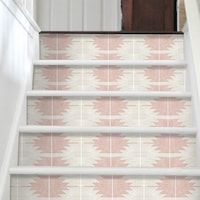 a stair case with pink and white wallpaper on the bottom, next to an open door