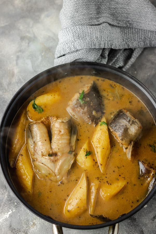 a pan filled with meat and potatoes covered in gravy on top of a table