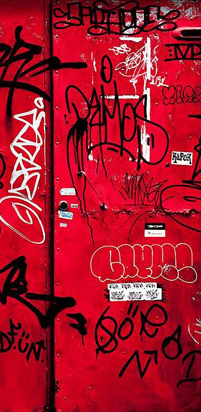 a red door covered in lots of graffiti